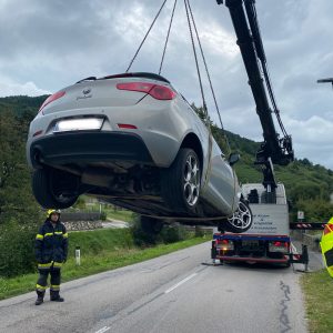 PKW der von Kran hochgehoben wird.